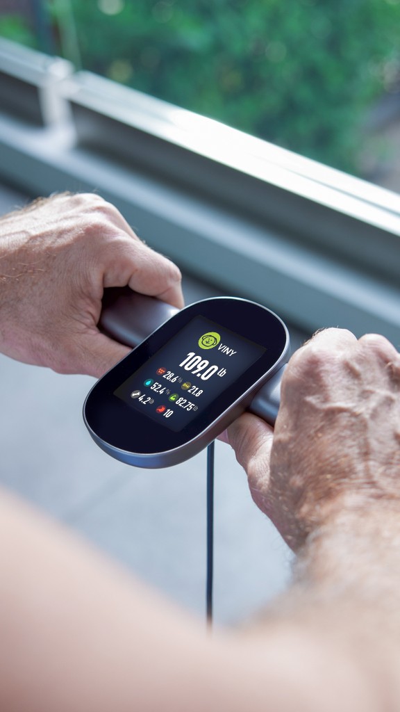 An Oxiline smart scale reading body-composition metrics in a patient's hands